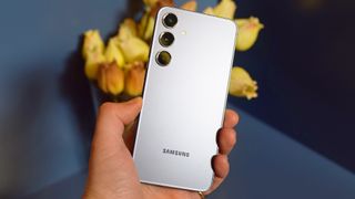 Samsung Galaxy S24 con manos en la computadora de mano con respaldo recto blanco