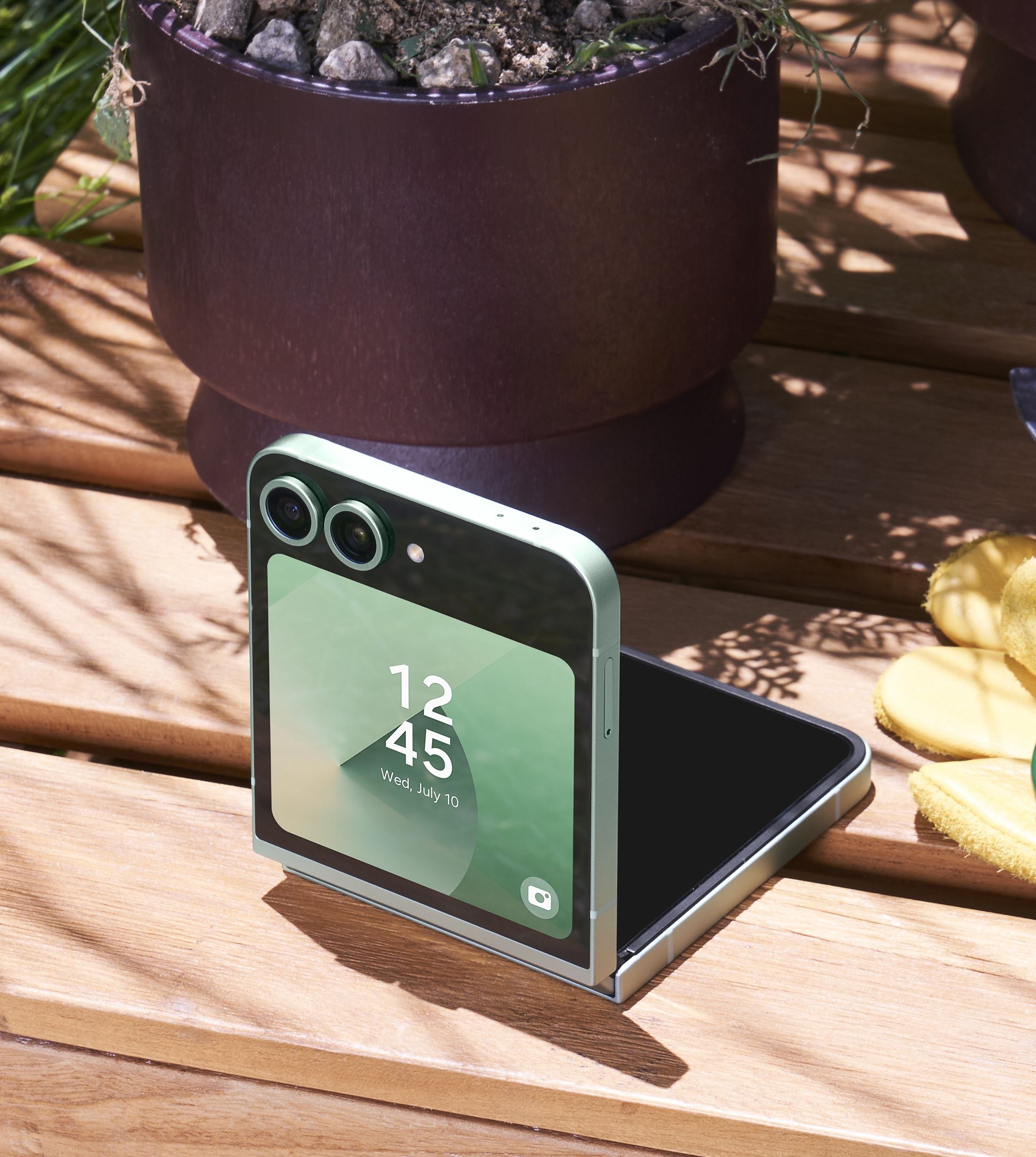 Samsung Galaxy Z Flip 6 en color menta, opción entreabierta en un banco de madera
