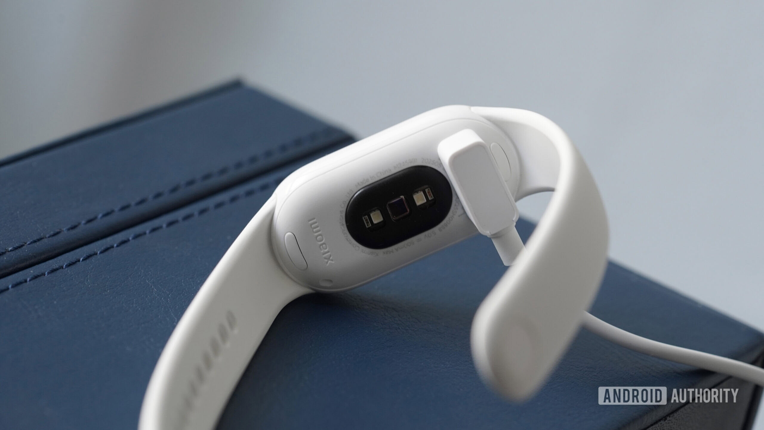 Un Xiaomi Smart Band 10 cobra en su cable de propietario.