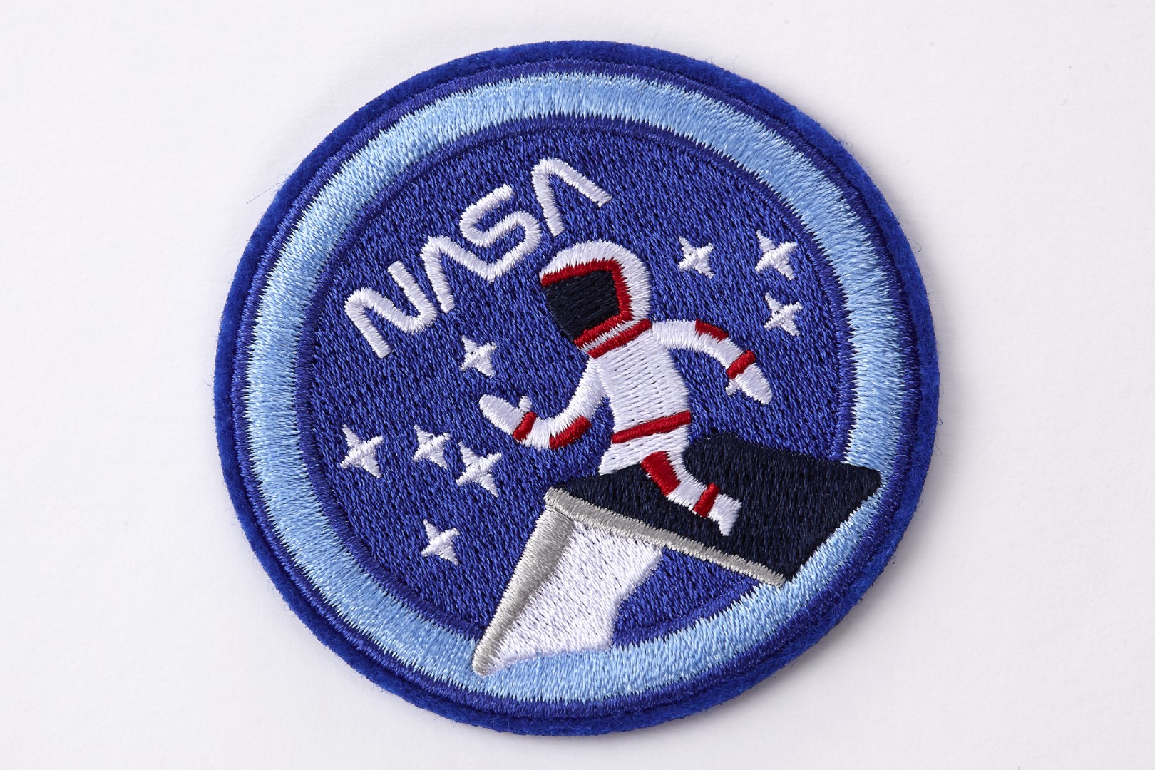 Patch bordado por los cuadernos de edición limitada inspirados en la NASA de Moleskine. Es un parche redondo azul oscuro con un borde azul. La palabra 