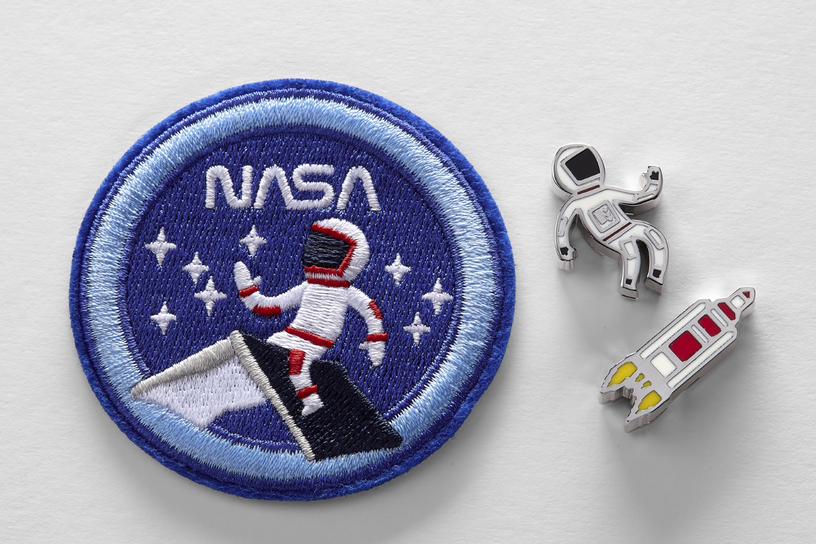 Parche bordado y 2 pines de los cuadernos de edición limitada inspirados en la NASA de Moleskine. El parche es un parche redondo azul oscuro con un borde azul. La palabra 