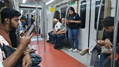 NurPhoto vía Getty Images La gente revisa sus teléfonos móviles dentro del Metro de Calcuta 