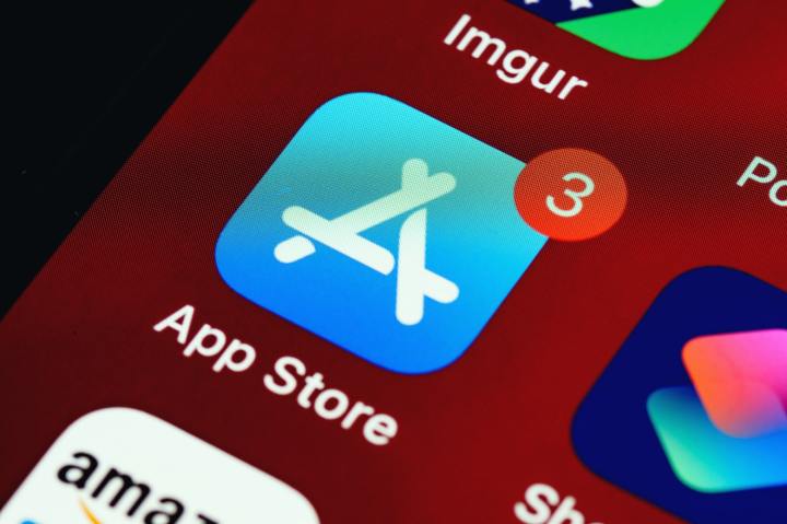 Una foto de una pantalla de Apple y un primer plano del ícono de la App Store con tres notificaciones.