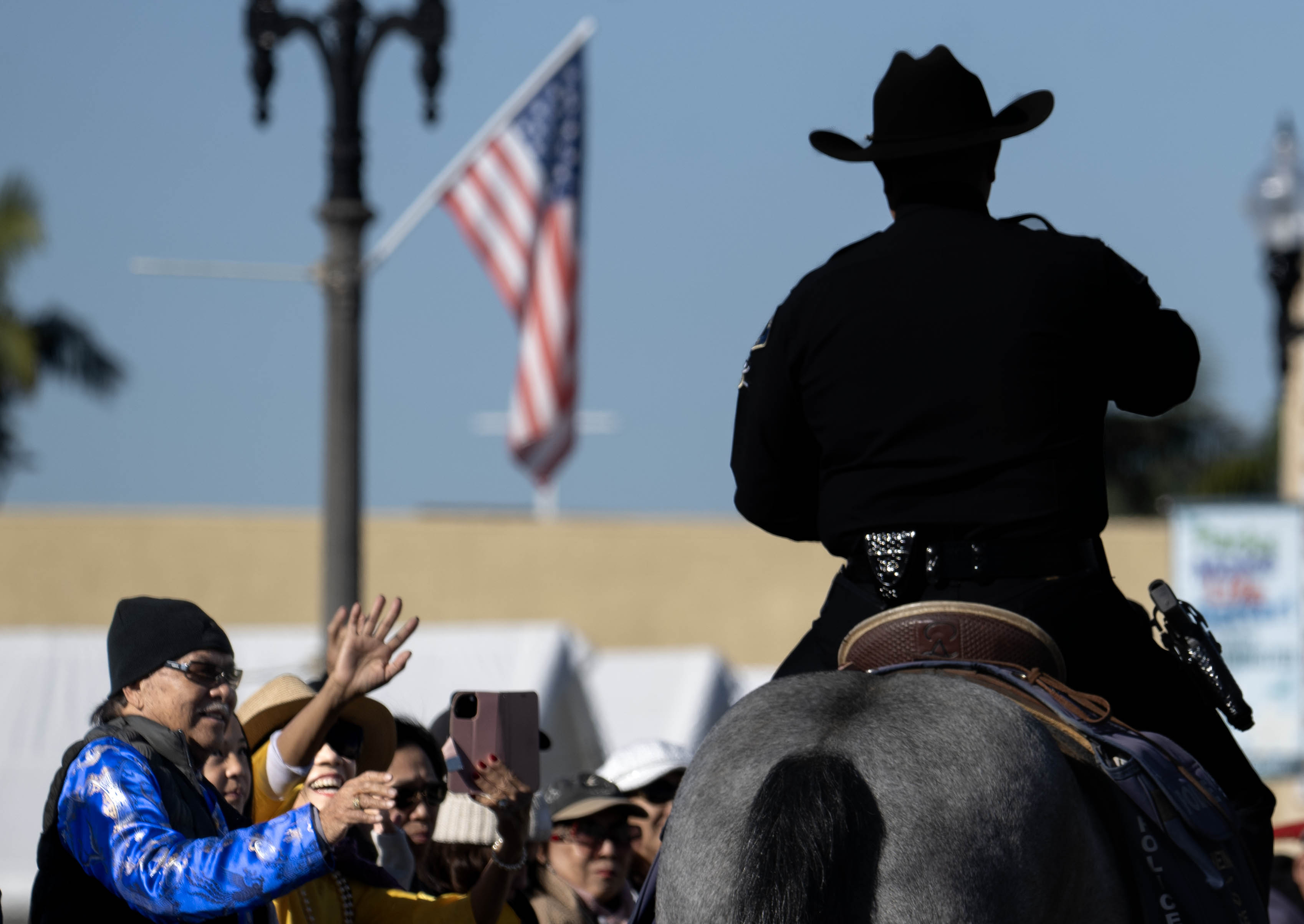 Los espectadores saludan a la Patrulla Montada del Departamento de Policía de Anaheim durante...