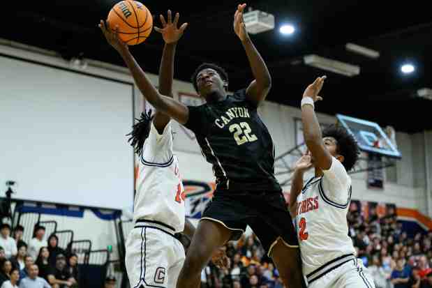 Tolu Akomolafe (22) de Canyon dispara bajo la presión de Emmanuel Igbekoyi (izquierda) de Cypress y Jaharii Hall (2) de Cypress durante la segunda mitad de un partido de baloncesto masculino de la Liga Crestview el viernes 30 de enero de 2026 en Cypress, California (Foto de William Liang, fotógrafo colaborador)