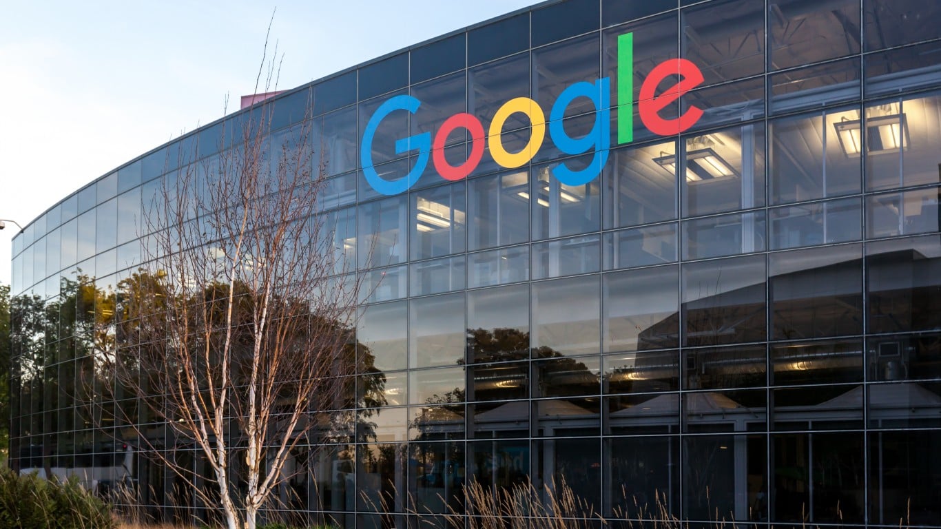 Un edificio grande y moderno con una fachada de cristal curvada. El logo multicolor