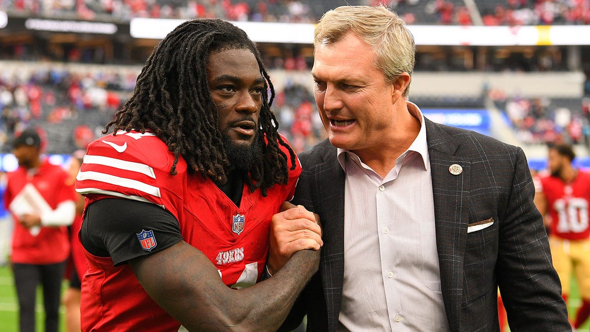 El receptor abierto de los 49ers de San Francisco, Brandon Aiyuk, celebra con el gerente general John Lynch en el estadio SoFi